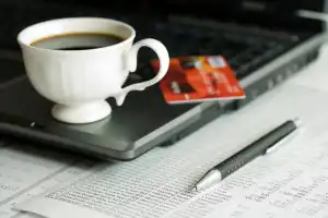 image of coffee cup on laptop on financial reports