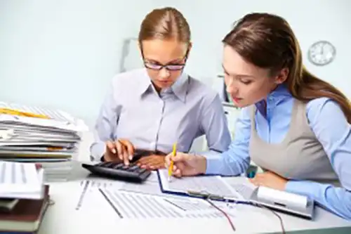 image of two women reviewing corporate tax returns with agent