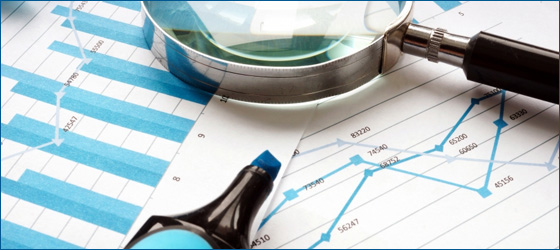 image of magnifying glass on top of financial reports