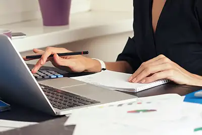 image of woman using a laptop computer doing bookkeeping and accounting